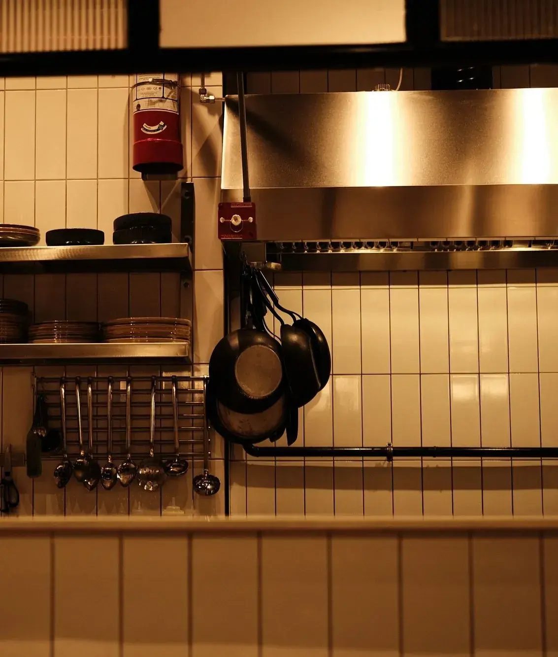 Restaurant kitchen with a fire suppression cylinder above the cooking hood